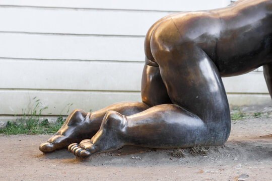 Prague, Czech Republic - June 23, 2022: Bronze feet and booty of a huge baby statue. Famous sculpture Crawling Babies by Czech artist David Cerny in Prague