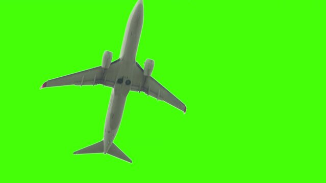 Slow motion, bottom view - white passenger airplane, airliner is flying against green background. Chroma key, green screen and template concept