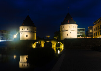 Fototapeta premium Illuminated night view of Broel Towers along the river Lys in Kortrijk, Belgium