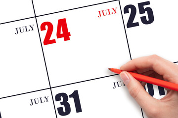 A hand holding a red pen and pointing on the calendar date July 24. Red calendar date, copy space,...