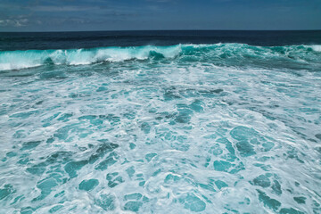 Big waves breaking on the beach - clear beautiful turquoise blue ocean sea and clouds in the sky - Bali