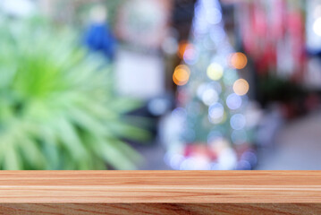 Empty wooden table on blurred bokeh christmas tree lights background.