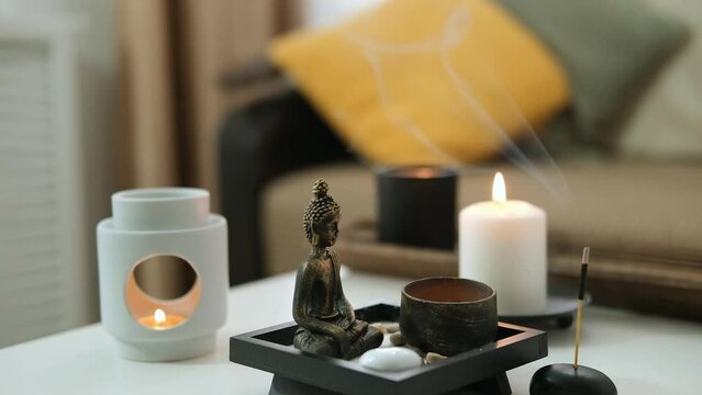 Vintage bronze statuette with candlestick made of copper. Statue of Buddha, incense sticks and burning candle. Aromatherapy, home fragrance. Concept of home relaxation and anti stress, zen buddhism.