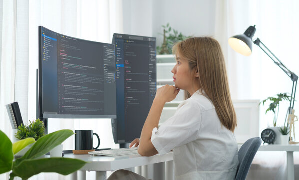 Concentrated  female software developer reading  analyzing data, programming code on computer screen.