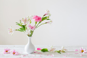 pink and white flowers in vase on white background