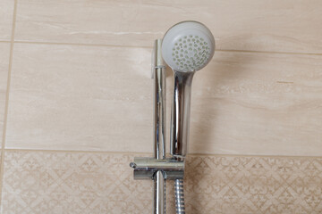Chrome-plated shower head mounted on the wall. contemporary bathroom. front view from below. © Viacheslav