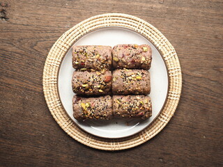 Cereal and nut crusted bread rolls on white plate