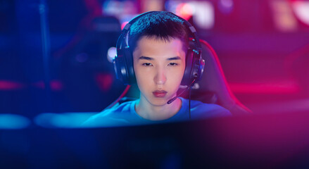 Fototapeta premium Beauty Young asian man pro gamer streamer playing in online video game, neon color soft focus. Concept banner cyber esport