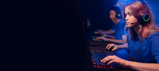 Streamer young woman professional gamer playing online games computer with headphones. Concept banner esport, neon color soft focus © Parilov
