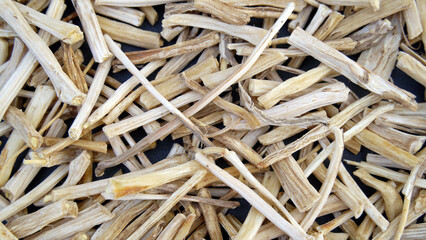 Close up of Ayurvedic herb Satavari or kurilo or Asparagus racemosus isolated on white in a glass bowl.