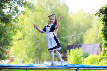 Children in school uniforms walk on the street. Children rejoice and have fun at the end of the school year. Holidays.