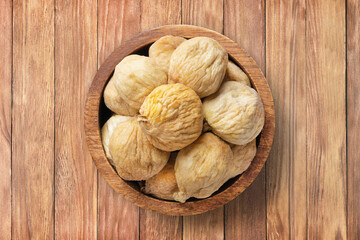 dried figs in bowl on wooden table background, top view. organic vegetarian food.