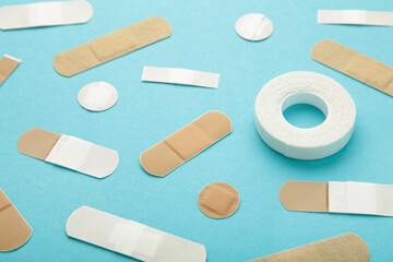 Beige adhesive bandages on blue background. Medical plasters