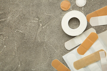 Beige adhesive bandages on grey background. Medical plasters