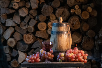 Rose wine in the wineglass and ripe grapes on wooden table. Grape harvest. Wine tasting culture. Sommelier pouring dessert wine in glass. Winery