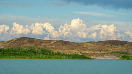 Beautiful cloudy sky on the lake. Lake Valley. Hills on the background of the lake