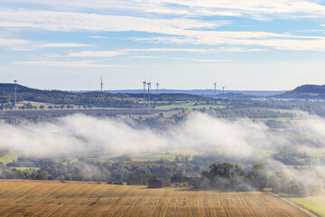 Landscape view with mist and wind turbines