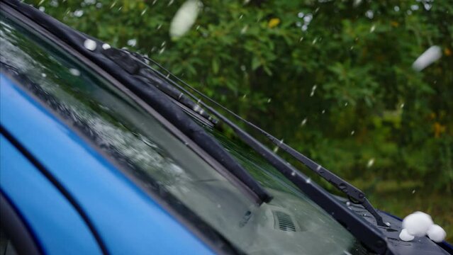 close-up of large hail falling during a ice storm on a car window