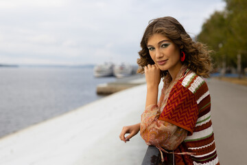 lifestyle of an elegant young woman on the embankment of a large river