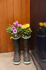 Flores plantadas en botas de agua para decoración.
