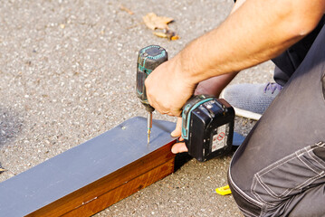 DIY work at home. young master repairing old garage doors. handyman repairing a rotten wooden building.