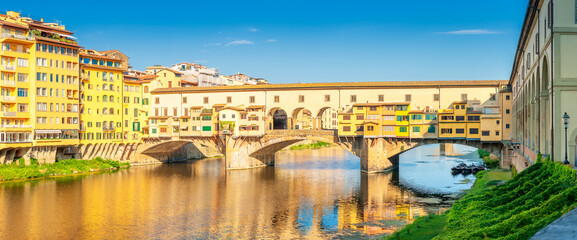 Panorama of beautiful medieval bridge Ponte Vecchio over Arno River, Florence, Italy. Architecture...