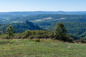 Fototapeta na wymiar Panorama sur la vallée de l'Allagnon avec ses vallées et son château de léotoing, toutes ses montagnes boiséees sur le chemin de randonnée des chaux dans le puy de dôme