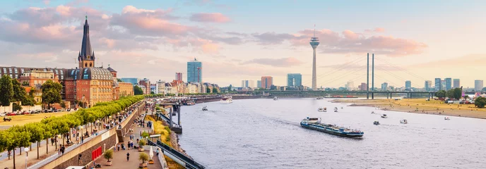 Foto op Plexiglas Stedelijk panoramisch stadsgezicht uitzicht op de oude binnenstad van Düsseldorf en transportwaterweg van heel Duitsland - de Rijn, waarlangs grote schepen en kleine schepen varen © EdNurg