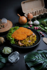 Fried Rice or Nasi Goreng from Indonesia with Crispy Chicken, Seasoning and Spices Isolated