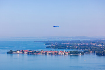 Zeppelin aircraft flying over the city of Lindau in the Bodensee lake, Germany, during summer © Simon van Hemert