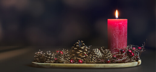 natural christmas decoration with red burning candle and pine cones in a 3d room, contemplative...