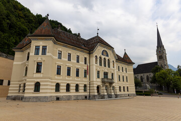 Fototapeta premium Government building of Liechtenstein on the Peter Kaiser Platz square in Vaduz with the cathedral of St. Florin in the background