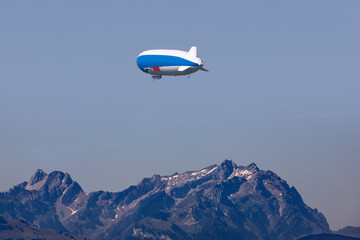 Zeppelin aircraft flying above the Bodensee, Austria, towards a mountain range
