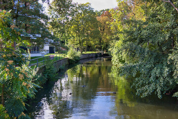 Naklejka premium Blick von der Schreberbrücke auf den Elstermühlgraben mit grünem Ufer und Spiegelungen im Wasser, Leipzig, Sachsen, Deutschland