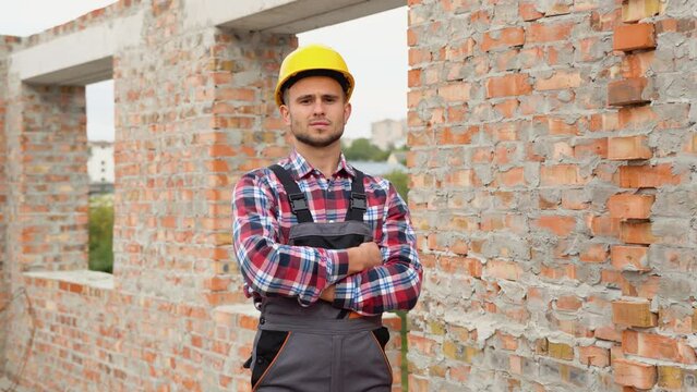 Portrait of satisfied and confident engineer with helmet on building site