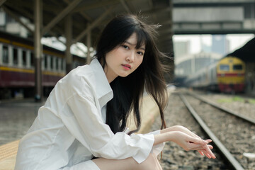 Portrait of thai japan adult beautiful girl white shirt blue jeans relax time, train station fashion