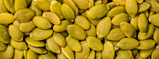 Pumpkin seeds peeled, close-up on a white background. Healthy seeds and nuts.