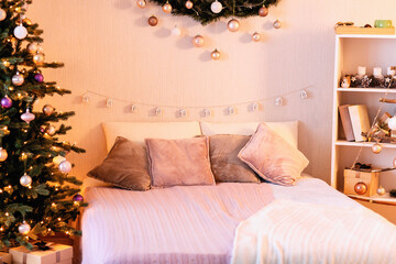 festive decoration of the bedroom by Christmas: balls in a wooden box, sculpture of deers, candles in a glass lantern, garland, handmade triangular pendant composition in the form of a tree with star