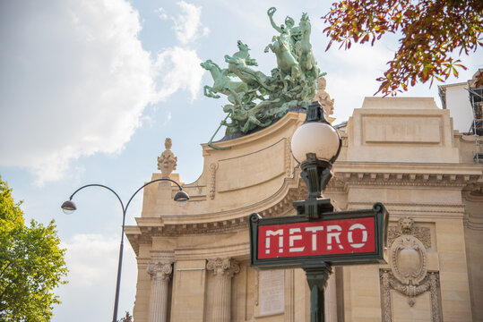 Paris, France. August 2022. traditional subway sign with historic building in the background.