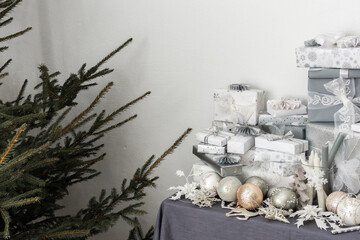 Preparations for the holiday, for dressing the Christmas tree, gifts and Christmas toys and decorations on the table near the fir tree