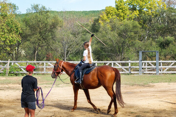 A girl rides a horse to master various elements of horseback riding.