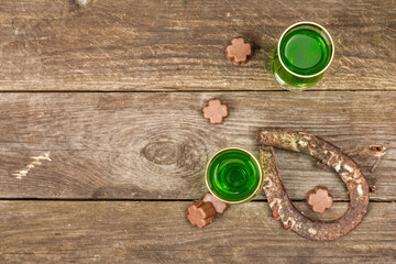 St. Patrick's Day concept. Traditional green cocktail, sweet chocolate in the shape of clover leaves