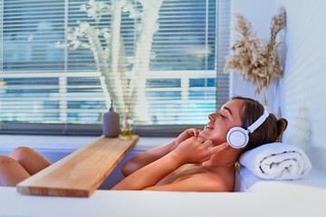 Relaxing woman listening calm music and taking a hot bath at home. Stress relief, support mind balance and mental health care