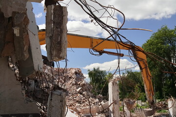 A large excavator during the demolition of an old building
Duża koparka podczas rozbiórki starego budynku