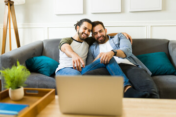 Happy young man hugging his boyfriend while watching a movie together