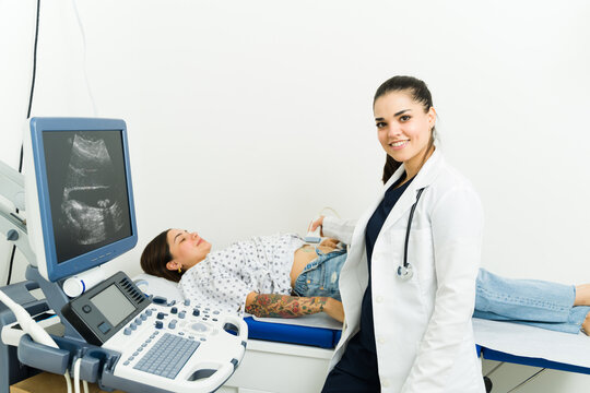 Happy technician checking the health of a pregnant woman with an ultrasound