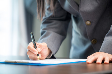 Workplace closeup person professional businesswoman sitting at desk hold pen signing or signature...