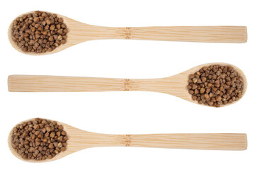 Buckwheat on an isolated white background. Buckwheat in a wooden spoons.