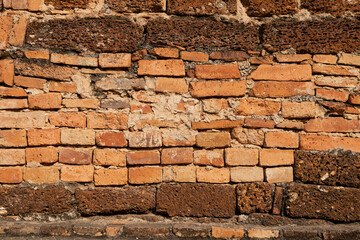 Textured background of a wall of bricks and irregular stones of reddish ochre colors, in one of the temples of Sukhothai Historical Park