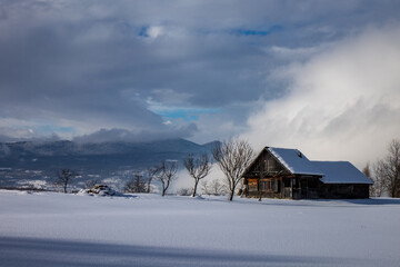 Landscape with the traditional house in the cloud and snow from Maramures. (Transylvania, Romania)
